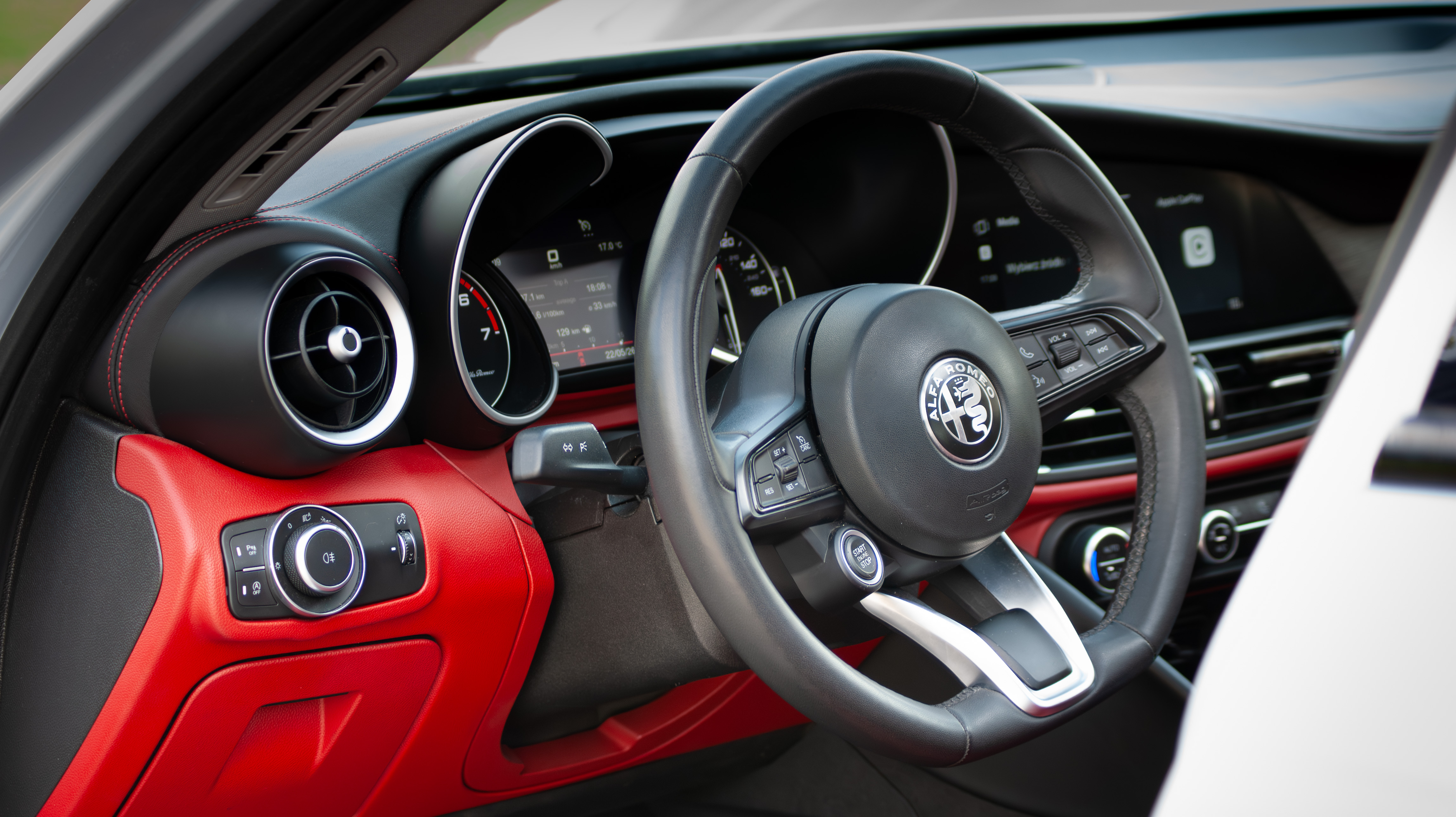 Czerwone skórzane wnętrze Alfa Romeo Giulia z logo Alfa Romeo na kierownicy